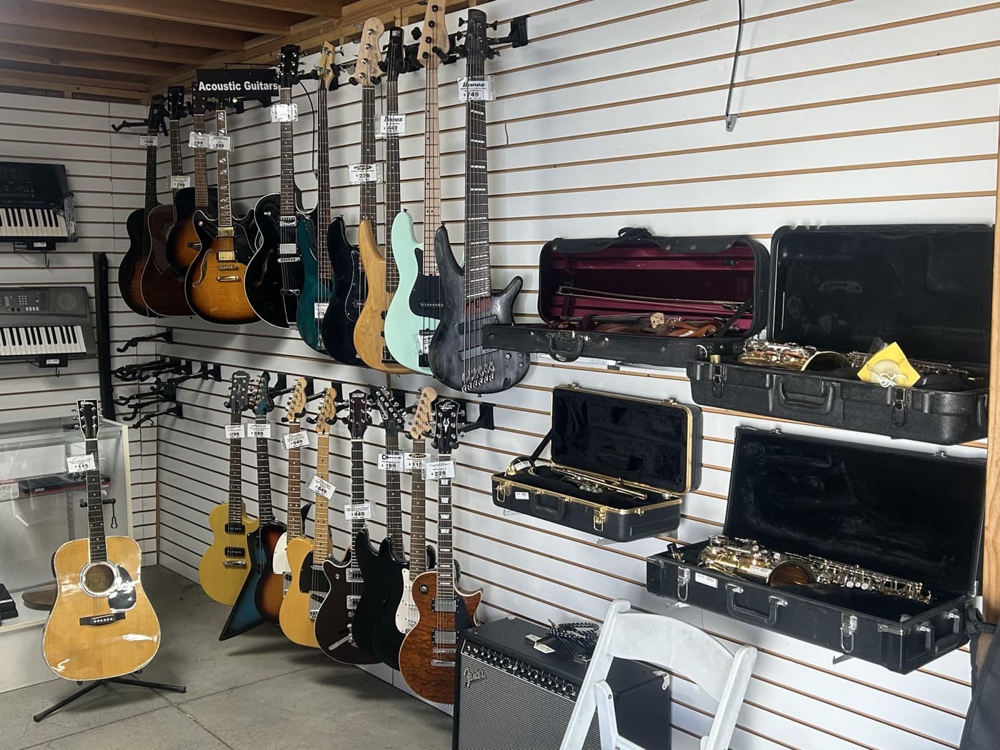 Guitars, basses, and saxophones displayed at Cash 1 Pawn
