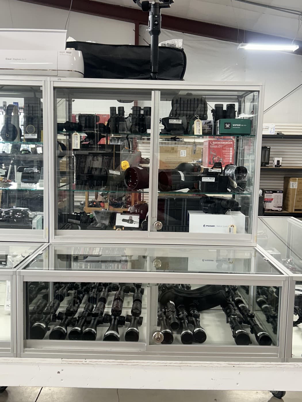 Binoculars and outdoor optics in a Cash 1 Pawn display case